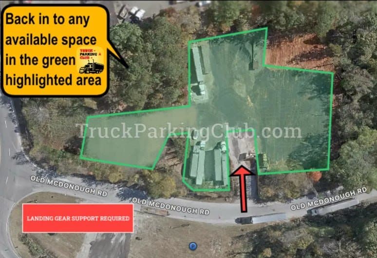 Aerial view of the yard on Old McDonough Rd. The parking area is shaded green; a red arrow marks the entrance from the road.